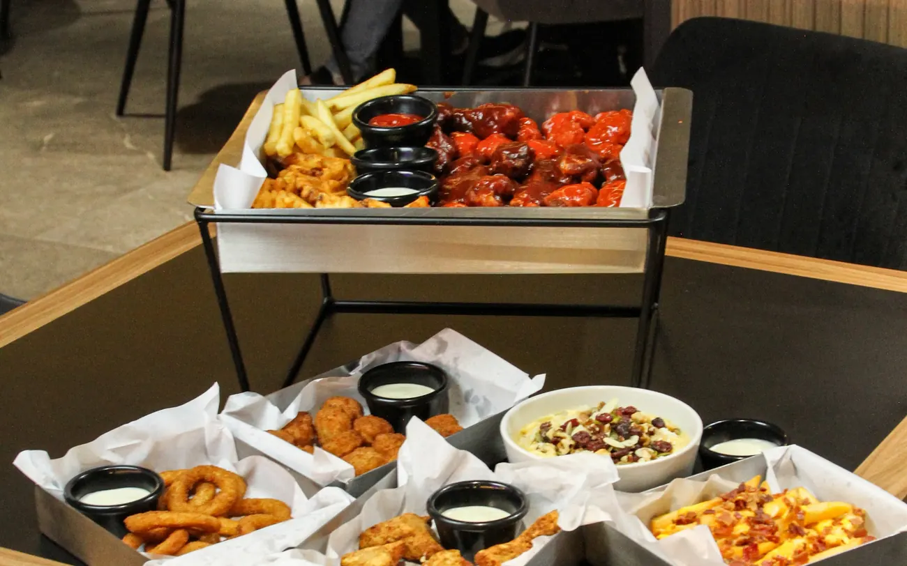 Mesa con alitas, boneless y dips